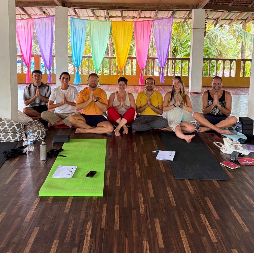 Solo travellers practising yoga together in Goa